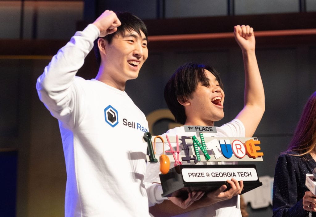 Jeff Mao (left) and Tyler Ma (right) celebrate while holding their InVenture Prize trophy.