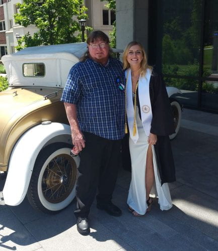 Heather Johnston poses with her father in front of the Reck.
